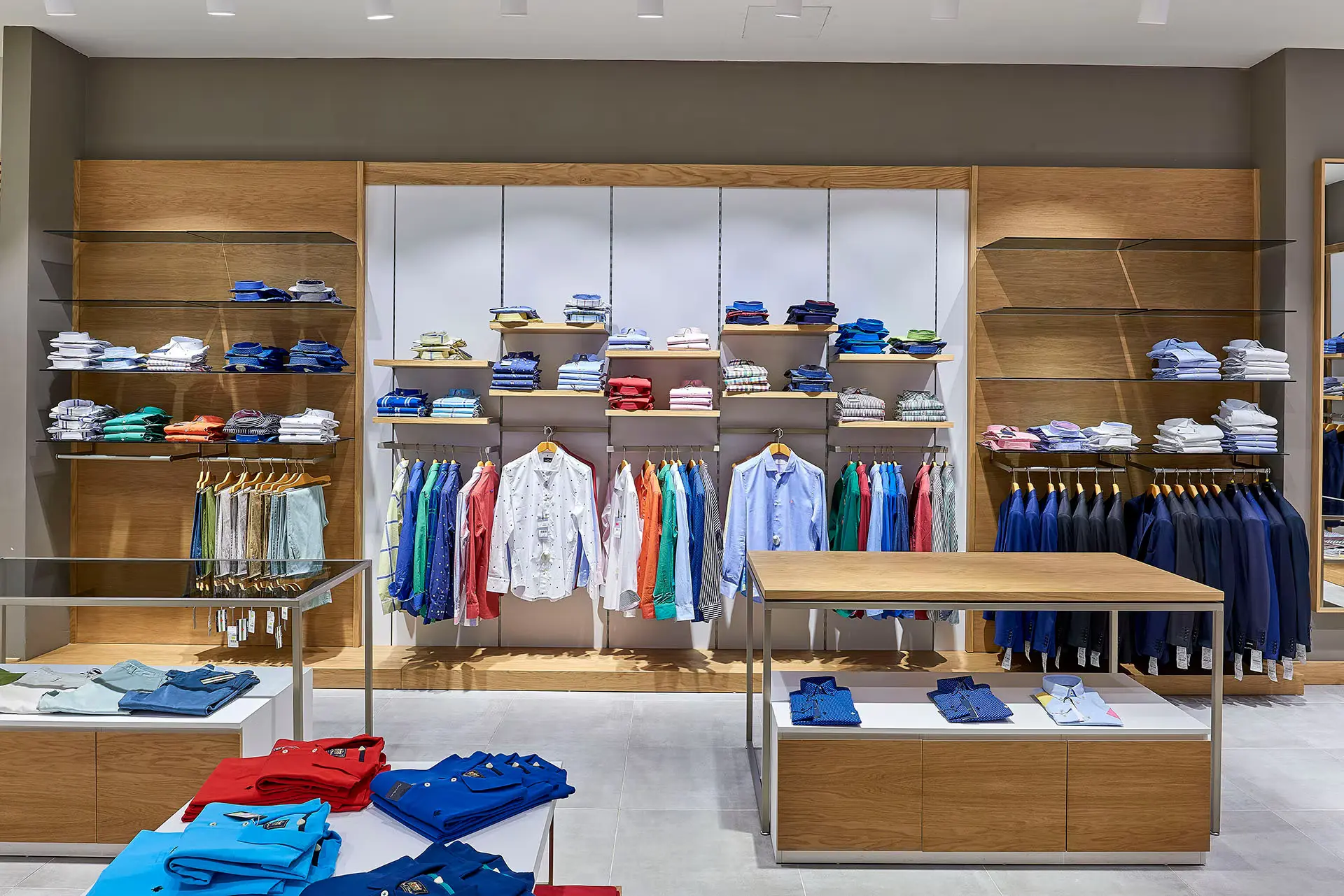 Apparel wall system with wood shelving and integrated rails